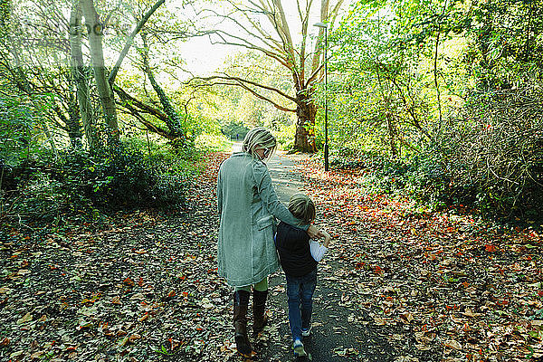 Mutter und Sohn beim Spaziergang in einem idyllischen Herbstpark