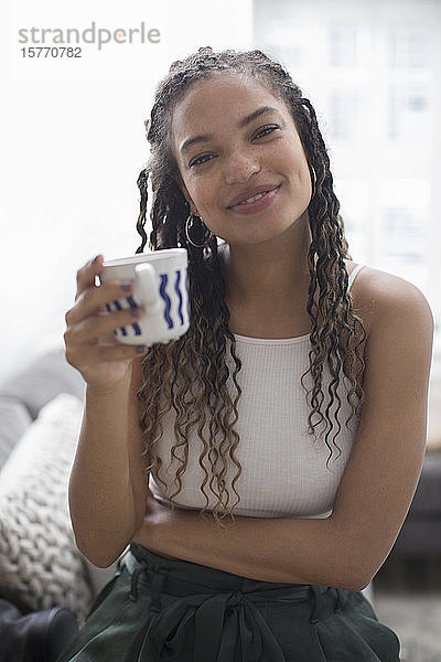 Portrait glückliche junge Frau beim Kaffeetrinken