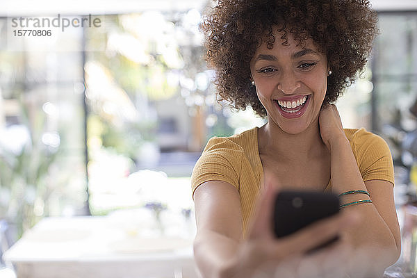 Verspielte glückliche junge Frau nimmt Selfie mit Kamera-Handy