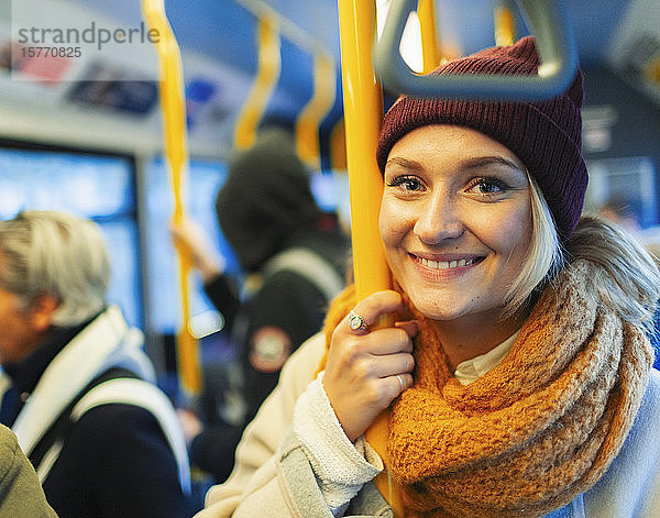 Porträt selbstbewusste junge Frau mit Strumpfmütze und Schal im Bus