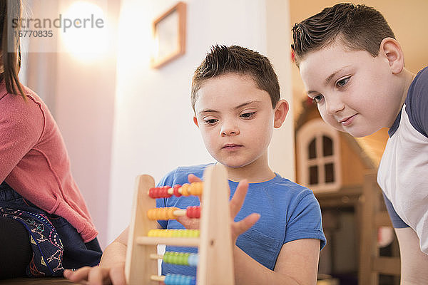 Junge mit Down-Syndrom und Bruder spielen mit Spielzeug