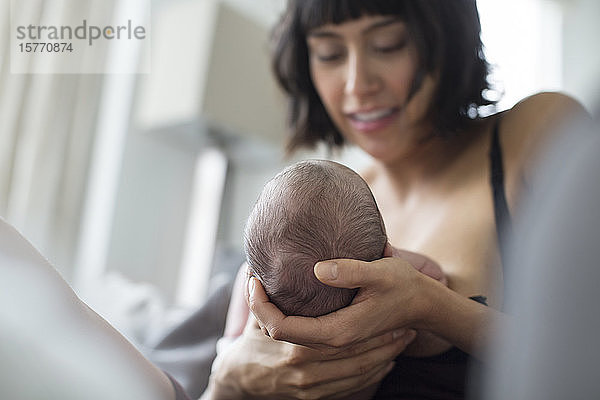 Mutter wiegt und stillt neugeborenes Baby Sohn