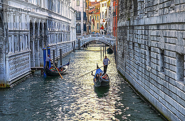 Gondel und Gondoliere mit Touristen in einem Kanal; Venedig  Italien