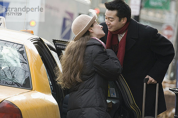 Junges Paar küsst sich in der Nähe eines Taxis
