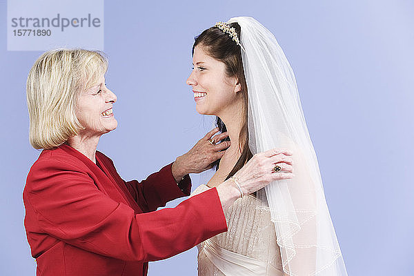 Seitenansicht der lächelnden Braut und ihrer Mutter.
