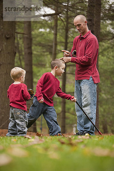 Ein Vater gibt seinem Sohn ein Zeichen  während sie im Herbst im Park spielen.