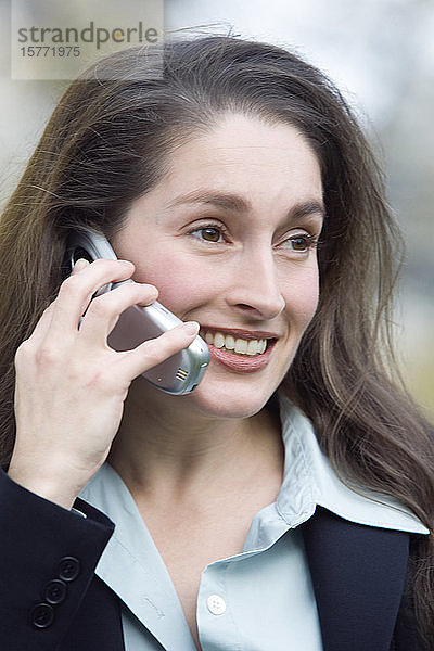 Nahaufnahme einer lächelnden Geschäftsfrau beim Telefonieren.
