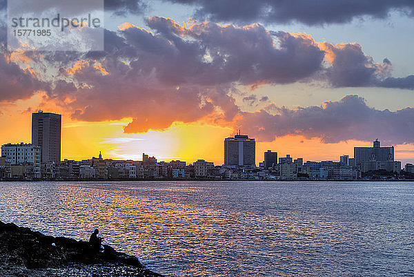 Skyline von Havanna mit Bucht bei Sonnenuntergang und einem einsamen Fischer im Vordergrund; Havanna  Kuba