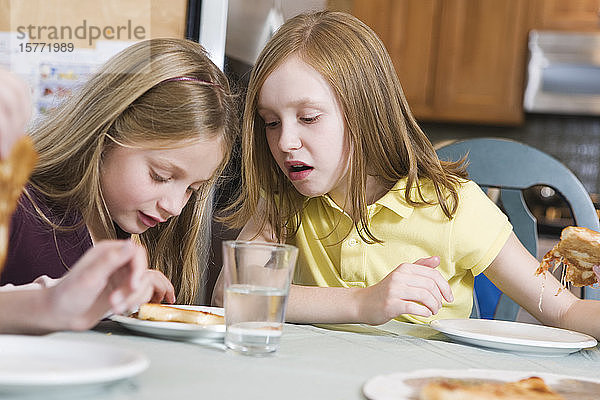 Blick auf zwei Mädchen  die einen Teller betrachten.