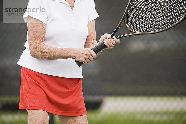 Mittelschnittansicht einer älteren Frau beim Tennisspielen