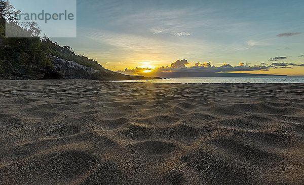 Die Sonne geht am Horizont unter auf diesem Landschaftsfoto mit Oberflächenansicht im weichen weißen Sand eines Strandes; Maui  Hawaii  Vereinigte Staaten von Amerika