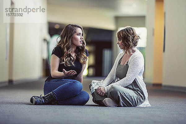 Eine junge Frau und ihr Jugendleiter diskutieren in einem Kirchenflur über ihren Glauben: Edmonton  Alberta  Kanada