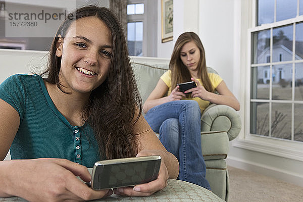 Zwei Mädchen im Teenageralter benutzen Smartphones