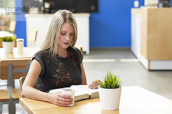 Eine reife Christin studiert ihre Bibel in einem Café: Edmonton  Alberta  Kanada