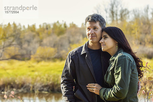 Ein reifes Paar genießt die gemeinsame Zeit und die Aussicht in einem Stadtpark an einem warmen Herbstabend; St. Albert  Alberta  Kanada