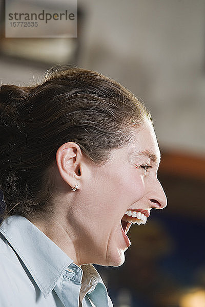 Profil einer lachenden jungen Frau.