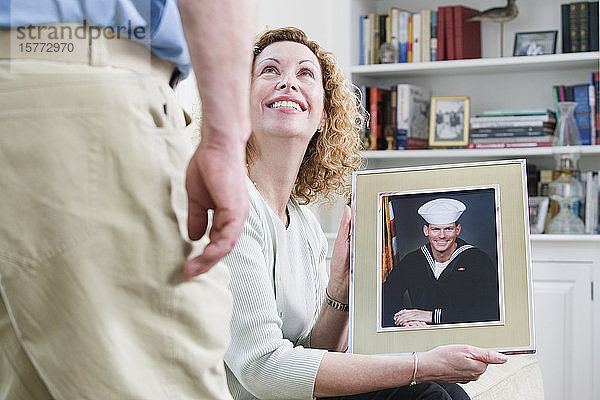 Frau zeigt Bild ihres Sohnes  der beim Militär arbeitet.