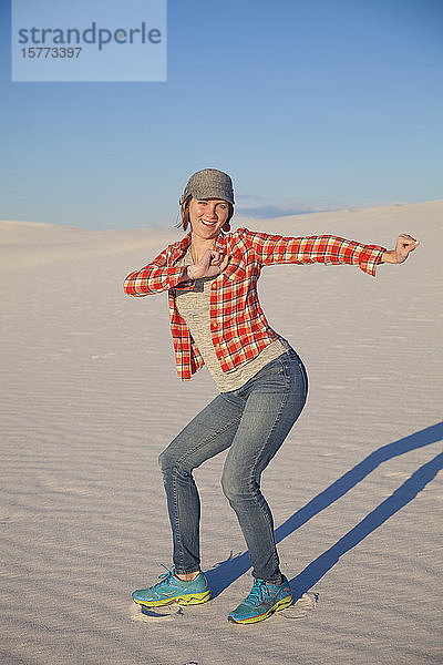 Unbeschwerte junge Frau auf dem weißen Sand mit blauem Himmel  White Sands National Monument; Alamogordo  New Mexico  Vereinigte Staaten von Amerika