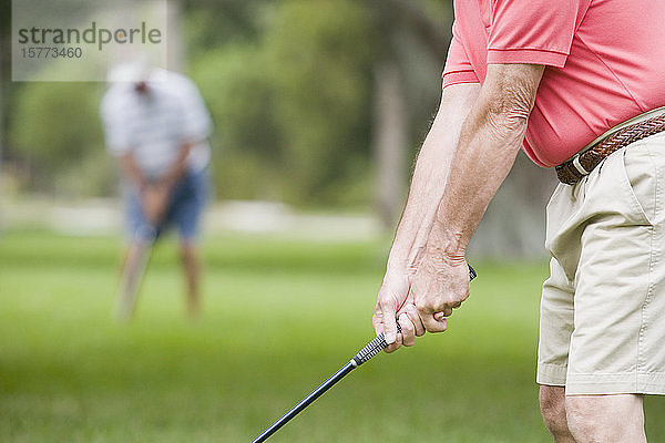 Mittelschnittansicht eines älteren Mannes beim Golfspielen