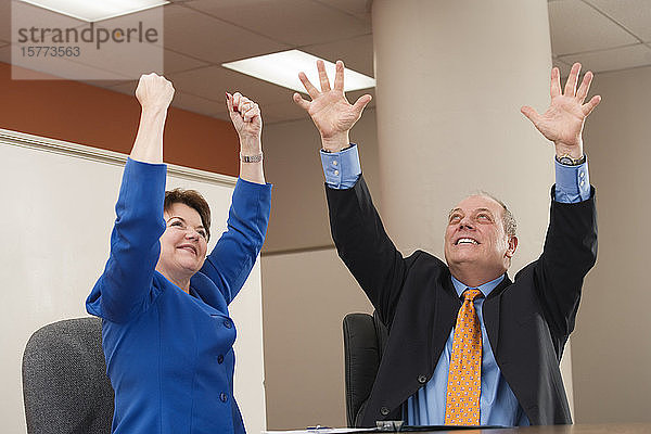 Geschäftsleute  die in einem Büro jubeln.