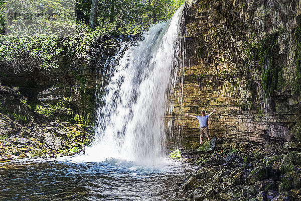 Männlicher Wanderer in einem Wasserfall entlang der Klippe  nördlich von Burlington; Ontario  Kanada