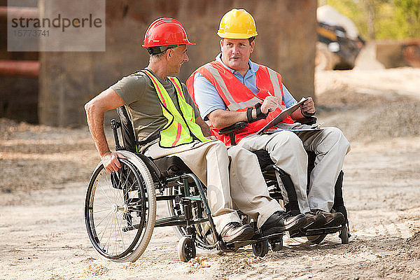 Baustelle mit Männern in Rollstühlen  die zusammenarbeiten