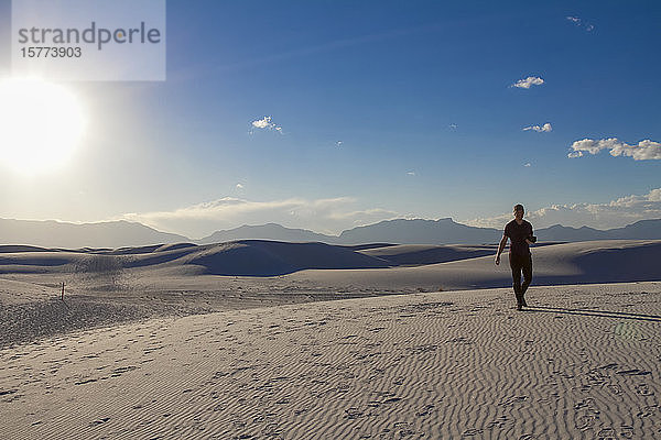 Männlicher Fotograf geht mit Kamera auf dem weißen Sand  White Sands National Monument; Alamogordo  New Mexico  Vereinigte Staaten von Amerika