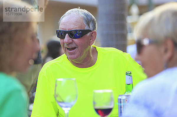 Älterer Mann und zwei Frauen mit Weingläsern zu Besuch