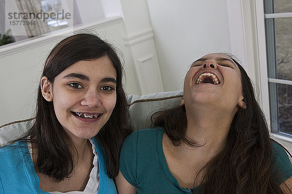 Zwei Mädchen im Teenageralter genießen die gemeinsame Zeit  die eine legt lachend den Kopf zurück