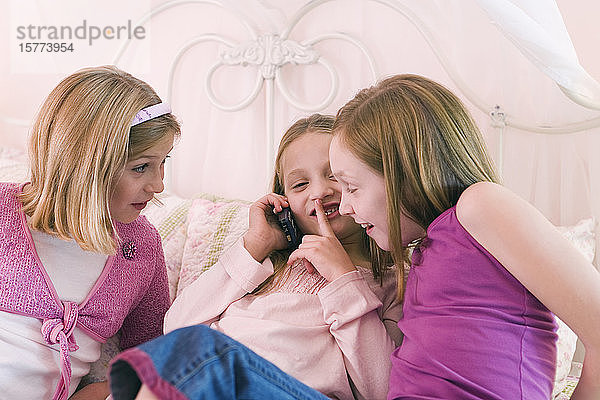 Blick auf drei süße Mädchen  die telefonieren.
