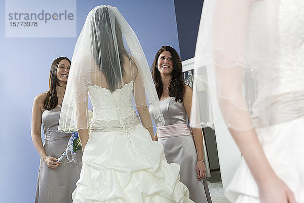 Reflexion einer Braut mit Brautjungfern im Spiegel.
