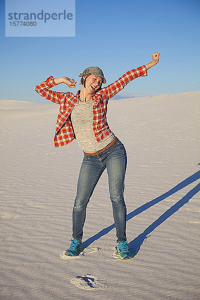 Unbeschwerte junge Frau auf dem weißen Sand mit blauem Himmel  White Sands National Monument; Alamogordo  New Mexico  Vereinigte Staaten von Amerika