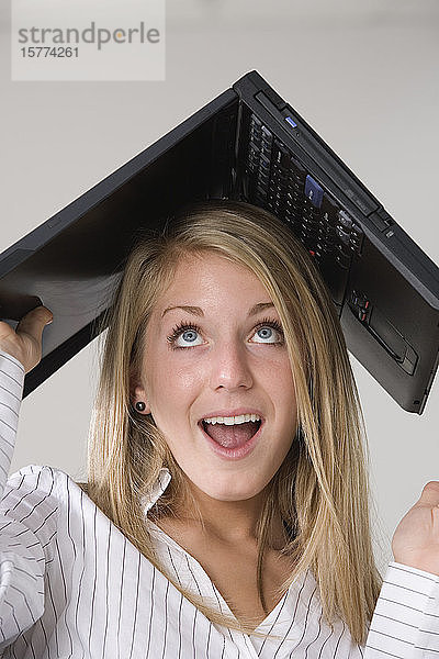 Eine Frau mit einem Laptop über ihrem Kopf.