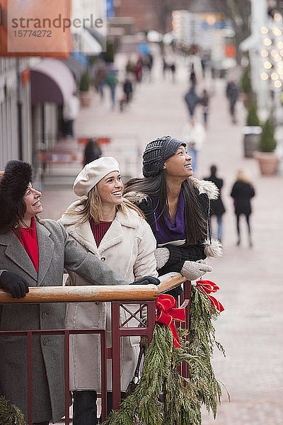 Drei Frauen stehen auf einem Balkon mit Weihnachtsschmuck und blicken auf die Stadt; Boston  Massachusetts  Vereinigte Staaten von Amerika