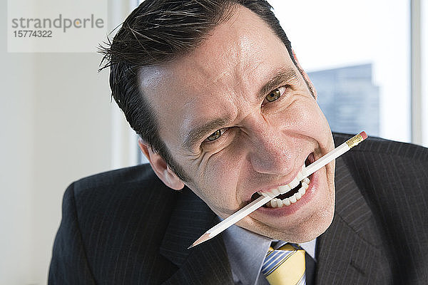 Porträt eines Geschäftsmannes mit Bleistift in einem Büro.