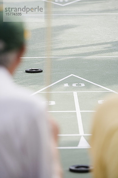 Rückansicht von zwei Männern  die Shuffleboard spielen