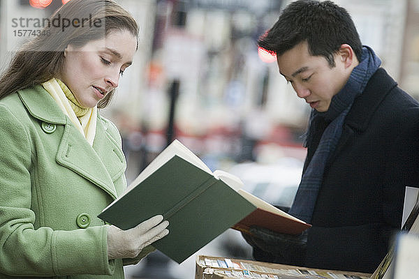 Nahaufnahme eines jungen Paares beim Lesen von Büchern in einem Geschäft