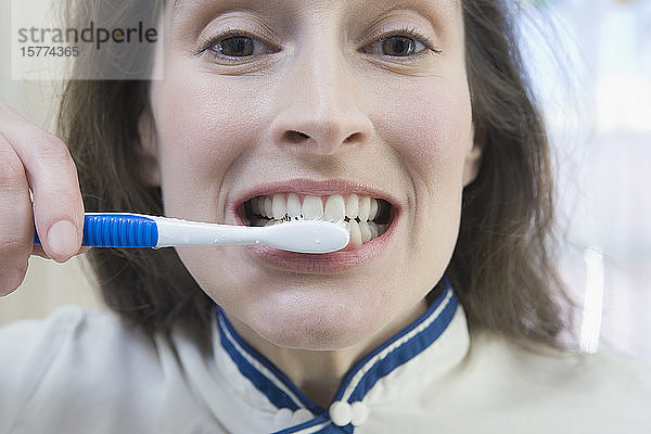 Porträt einer mittelalten Frau beim Zähneputzen