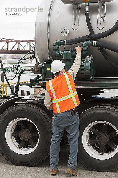 Umwelttechniker beim Einstellen der Pumpe eines Tankwagens bei der Abfallbeseitigung