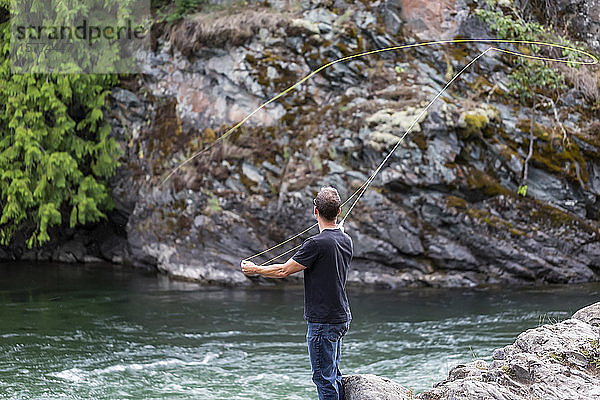 Ein Mann beim Fliegenfischen am Adams River  in der Nähe von Salmon Arm; British Columbia  Kanada