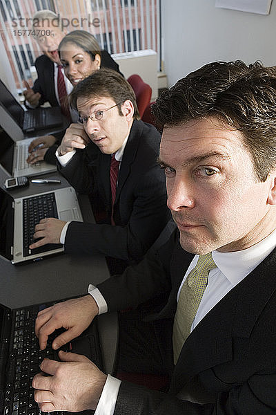 Porträt von Geschäftskollegen bei der Arbeit in einem Büro.