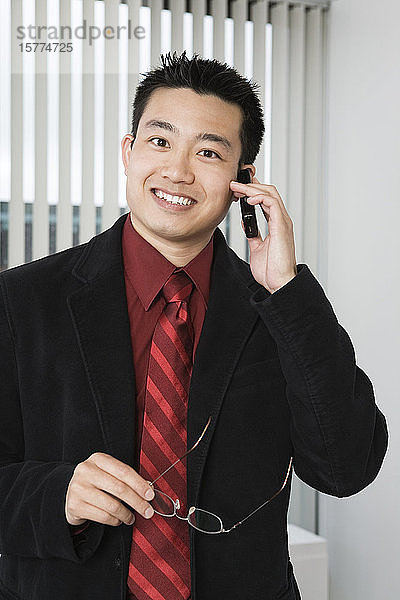 Porträt eines Geschäftsmannes  der ein Mobiltelefon benutzt.