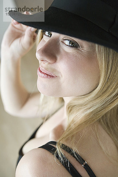Porträt einer erwachsenen Frau  die einen Hut trägt und lächelt