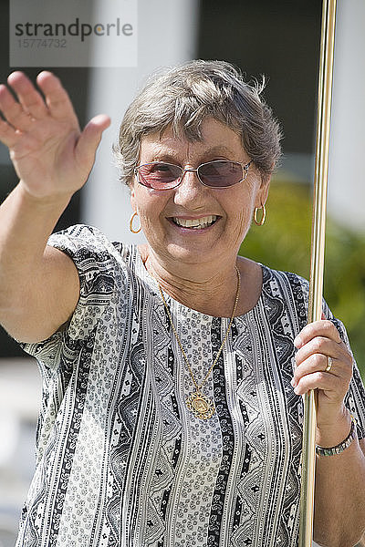 Ältere Frau spielt Shuffleboard und lächelt
