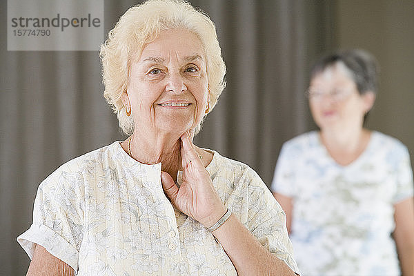 Ältere Frau überprüft ihren Puls nach dem Training in einem Fitnessstudio