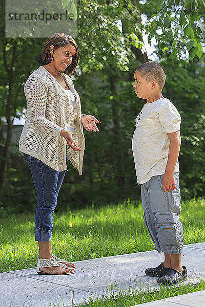 Mutter spricht mit Sohn im Teenageralter auf einem Weg im Freien