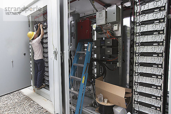 Handwerker bei Arbeiten an elektrischen Komponenten im Freien