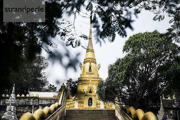 Außenansicht eines kleinen lokalen Tempels mit goldener Stupa.