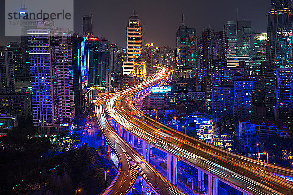 Erhöhte Ansicht eines gestapelten Straßenkreuzes und der Skyline von Shanghai in der Abenddämmerung  Shanghai  China