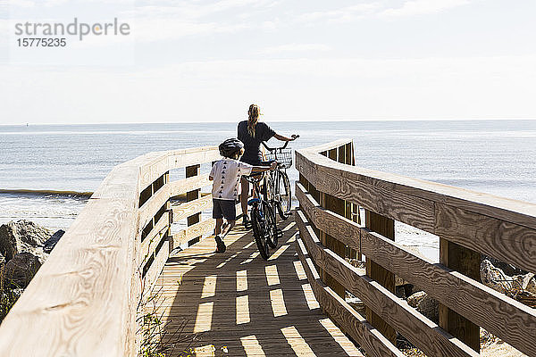 Zwei Kinder  Bruder und Schwester auf Holzbrücke mit Fahrrädern